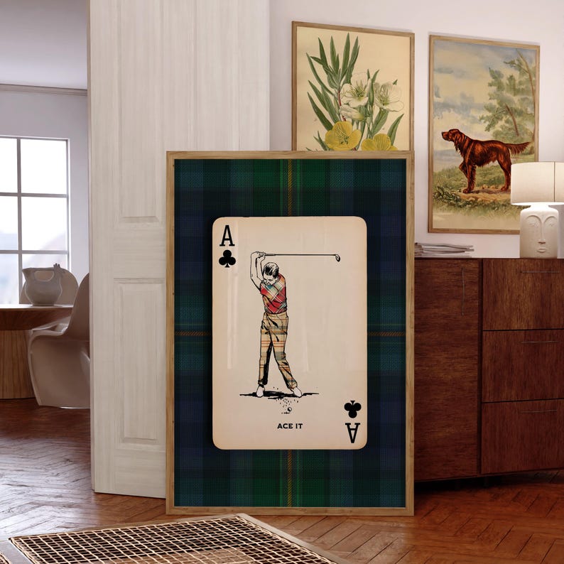 May include: A framed print featuring a playing card design with a golfer in action. The card is set against a green and navy plaid background. The card shows the Ace of Clubs and the text "ACE IT".