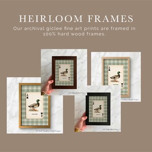 May include: Four framed prints featuring a mallard duck illustration on an ace of clubs playing card against a sage green gingham background. The frames are available in gold, dark wood, black, and maple finishes with text labels for sizes.
