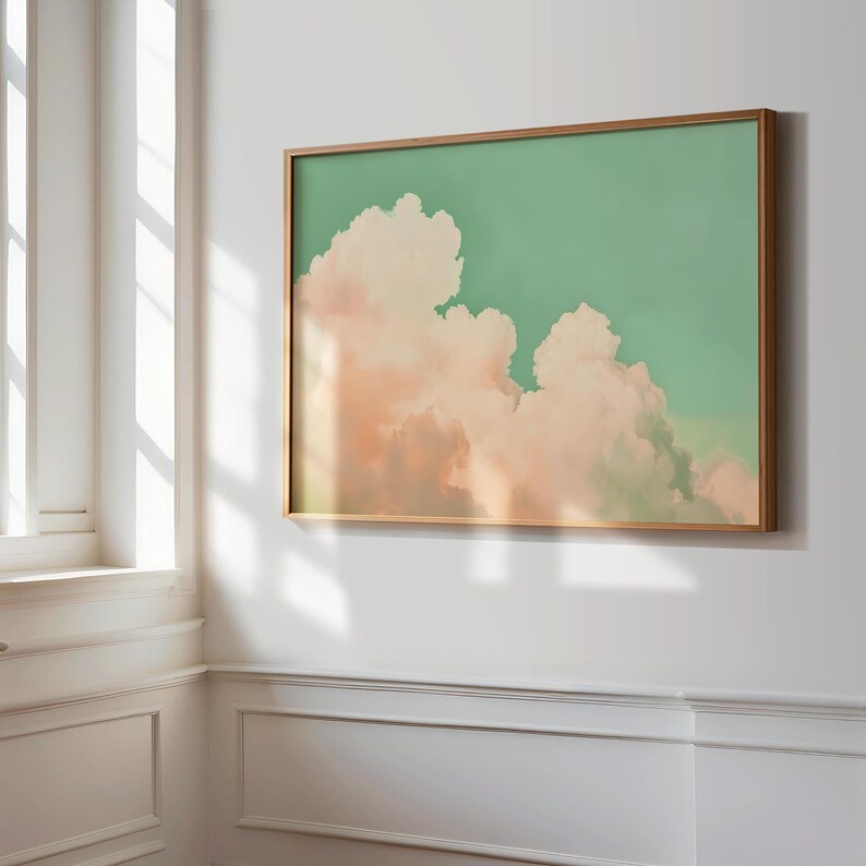 Panoramic wall art featuring billowing pink clouds against a soft sage green sky, creating airy Western big-sky artwork ideal for farmhouse, ranch, or modern bedroom décor. Shown here as stretched canvas framed in our custom oak frame.