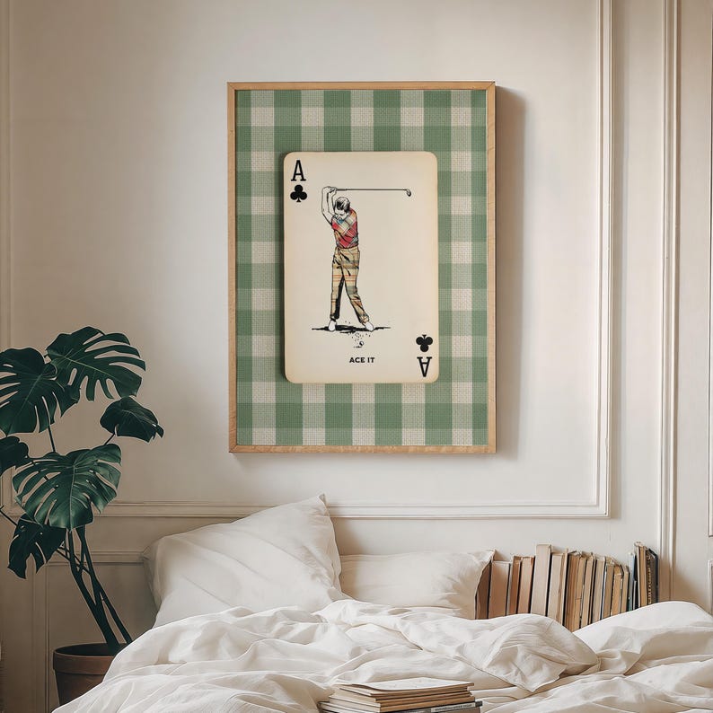 K&ouml;nnte beinhalten: Ein rechteckiger Wandkunstdruck mit einer cremefarbenen Spielkarte, einem Kreuz-Symbol und dem Text ACE IT. Die Karte zeigt die Illustration eines Golfers, der einen Schl&auml;ger schwingt. Der Hintergrund ist ein gr&uuml;n-wei&szlig;es Vichy-Muster.