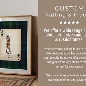 May include: Framed artwork featuring a playing card with a golfer illustration, set against a green and blue plaid background. The frame is a light wood color. Text on the image says "CUSTOM Matting & Frames".