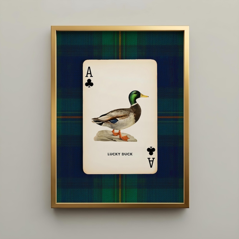 May include: A framed print featuring a playing card design with a mallard duck illustration. The card is labeled "Lucky Duck" and framed in gold, set against a plaid background. The card shows the Ace of Clubs.