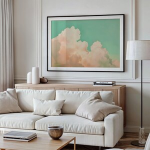 Panoramic wall art featuring billowing pink clouds against a soft sage green sky, creating airy Western big-sky artwork ideal for farmhouse, ranch, or modern bedroom décor. Shown as a giclée fine art poster print with 1.5" white mat and black frame. Message for this custom finishing.