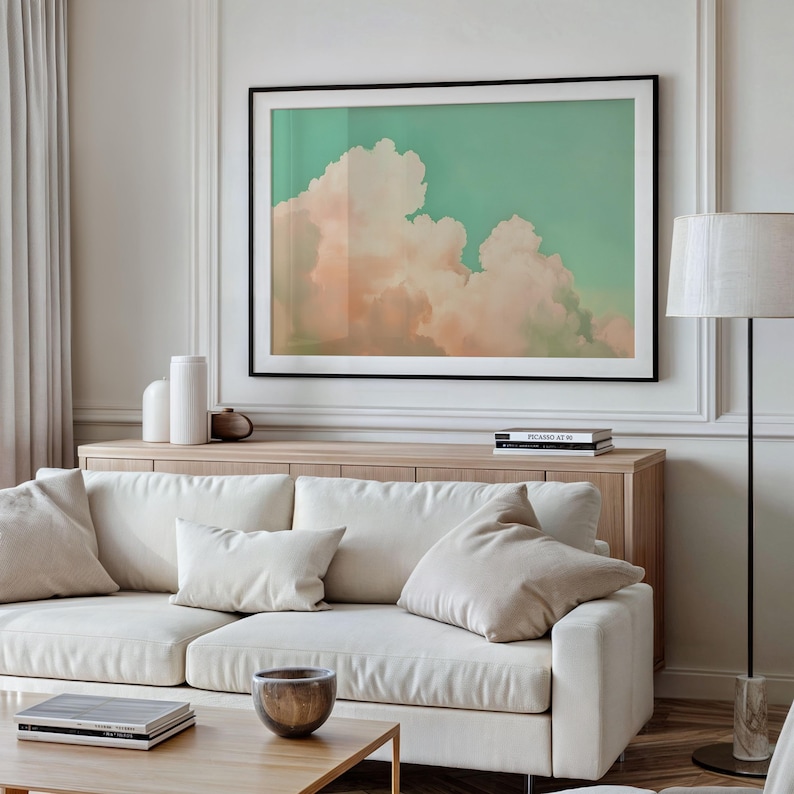 Panoramic wall art featuring billowing pink clouds against a soft sage green sky, creating airy Western big-sky artwork ideal for farmhouse, ranch, or modern bedroom décor. Shown as a giclée fine art poster print with 1.5" white mat and black frame. Message for this custom finishing.