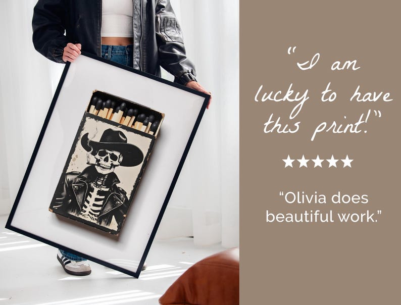 May include: A framed print of a black and white illustration of a skeleton wearing a cowboy hat and leather jacket. The skeleton is holding a cigarette and is surrounded by matches in a box. The text "I am lucky to have this print!" and "Olivia does beautiful work." is written below the image.