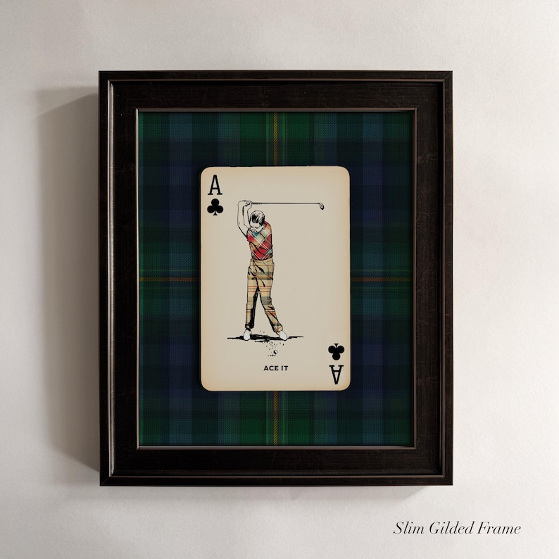 May include: Framed artwork featuring a playing card design. The card is the Ace of Clubs, with an illustration of a golfer in action. The background is a green and blue plaid pattern, and the frame is black. The text "ACE IT" is at the bottom of the card.