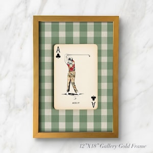 K&ouml;nnte beinhalten: Ein gerahmtes Wandbild mit einer Kreuz-Ass-Spielkarte, einer Golfer-Illustration und dem Text ACE IT. Die Karte ist vor einem gr&uuml;n-wei&szlig;en Vichy-Karo-Hintergrund in einem 30,48 cm mal 45,72 cm gro&szlig;en, goldfarbenen Metallrahmen platziert.