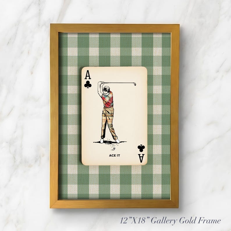 K&ouml;nnte beinhalten: Ein gerahmtes Wandbild mit einer Kreuz-Ass-Spielkarte, einer Golfer-Illustration und dem Text ACE IT. Die Karte ist vor einem gr&uuml;n-wei&szlig;en Vichy-Karo-Hintergrund in einem 30,48 cm mal 45,72 cm gro&szlig;en, goldfarbenen Metallrahmen platziert.