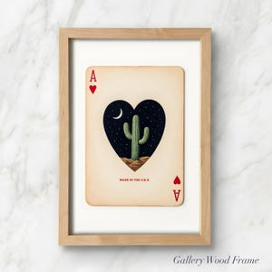 May include: A framed art print of the Ace of Hearts playing card. The card features a heart-shaped design with a cactus under a crescent moon and starry night sky. The text "MADE IN THE U.S.A." is printed at the bottom.