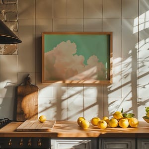 Panoramic wall art featuring billowing pink clouds against a soft sage green sky, creating airy Western big-sky artwork ideal for farmhouse, ranch, or modern bedroom décor. Shown here as a fine art giclée print finished in our oak frame.