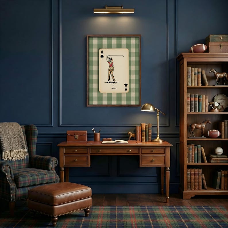 K&ouml;nnte beinhalten: Ein gerahmter Kunstdruck, der eine Kreuz-Ass-Spielkarte mit einer Golfer-Illustration vor einem gr&uuml;n-wei&szlig; karierten Hintergrund zeigt. Das Kunstwerk befindet sich in einem Arbeitszimmer mit einem Holzschreibtisch, einem Lederhocker und einem B&uuml;cherregal.