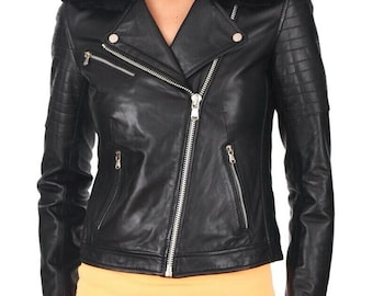 May include: A black leather jacket with a black fur collar. The jacket has a silver zipper, multiple pockets, and quilted detailing on the shoulders. The model is wearing a yellow shirt and blue jeans.
