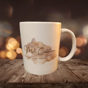Könnte beinhalten: Weiße Keramiktasse mit einem braunen Aquarelldesign und dem Text "Mat Creation - Flocage - Sublimation - Creation" auf der Vorderseite.