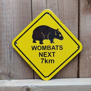 Letrero de metal esmaltado de porcelana vintage WOMBATS CROSSING 7KM de 8" x 8"