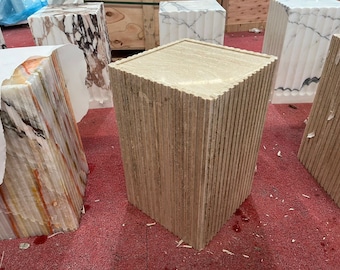 Puede incluir: Cuatro pedestales de mármol diferentes con un diseño acanalado. Los pedestales son de varios tonos de blanco, marrón y beige. Los pedestales están sobre una alfombra roja.