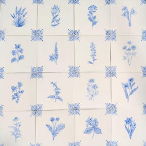 Peut inclure: Carreaux blancs avec des motifs floraux bleus. Chaque carreau présente une illustration botanique différente, comme de la lavande et des marguerites. Des ornements bleus décorent les coins de chaque carreau.