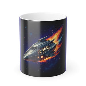 May include: A black and white ceramic mug featuring a stylized spaceship design with the text "31 ATI AS" in a space-themed background with stars and flames. The mug has a white interior.