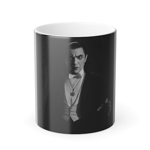 Op de afbeelding: Zwart-witte keramische mok met een portret van een man in formele kleding. De man draagt een smoking, een vlinderdas en een hanger. De mok heeft een witte binnenkant en een zwarte buitenkant met een glanzende afwerking.