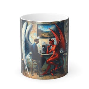 Puede incluir: Taza de cerámica blanca con una ilustración detallada de un ángel y un diablo sentados en un bar. El ángel tiene grandes alas blancas y un halo, mientras que el diablo es rojo con cuernos y alas. El fondo representa una escena de bar.