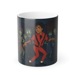 May include: White ceramic mug featuring a cartoon illustration of a person in a red outfit dancing in front of zombies. The background is a dark street scene. The mug has a white interior.