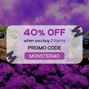 May include: A pink and white discount coupon with the text "40% OFF when you buy 2 items PROMO CODE MONSTER40". Two small, colourful, handmade creatures are on either side of the coupon.