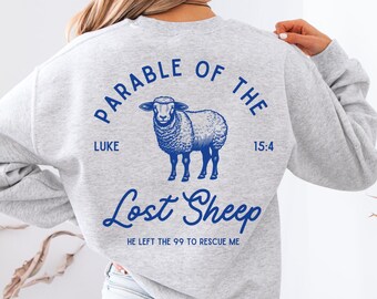 Può includere: Felpa grigia con una grafica blu di una pecora e il testo "Parable of the Lost Sheep Luke 15:4 He left the 99 to rescue me."