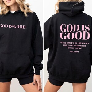 May include: Black hoodie with a pink "God is Good" graphic on the front and a longer quote on the back. The quote reads "Oh give thanks to the Lord, for he is good, for his steadfast love endures forever! Psalm 107:1"
