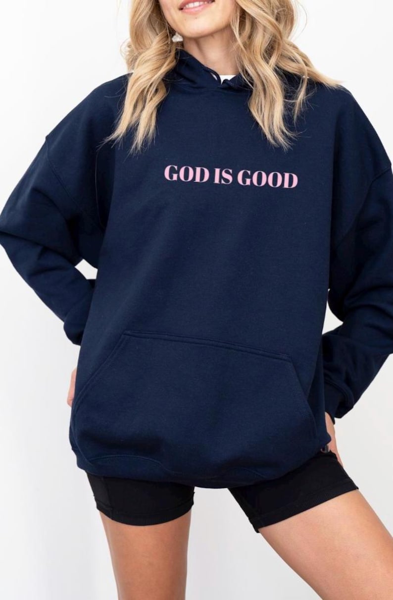 May include: A navy blue hoodie with a pink graphic that says "GOD IS GOOD".