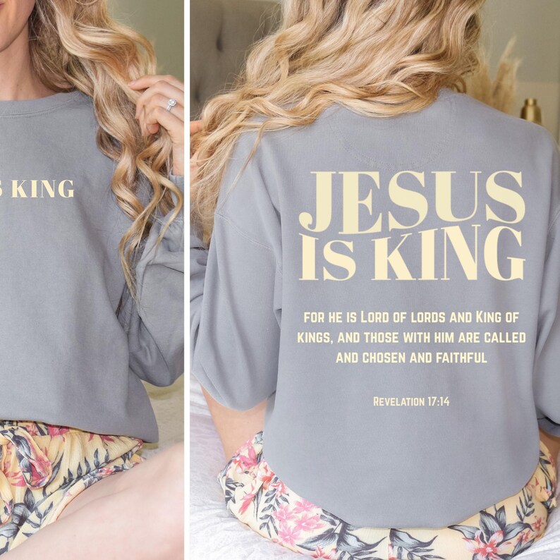 May include: Gray sweatshirt with the text "JESUS IS KING" on the back and front. The back of the sweatshirt also features a Bible verse from Revelation 17:14. The sweatshirt is a casual, comfortable style.