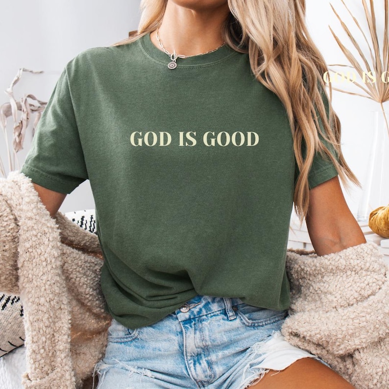 May include: A green t-shirt with the text "GOD IS GOOD" in a light yellow color.