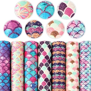 May include: Set of eight mermaid scale patterned fabric sheets. The fabric sheets are in various colours, including pink, blue, green, and purple. Each sheet has a different pattern of mermaid scales with glitter accents.