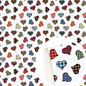 May include: A white background covered in a repeating pattern of heart shapes. The hearts are decorated with plaid and striped patterns in red, blue, orange, green, and brown. A close-up reveals the material's texture.