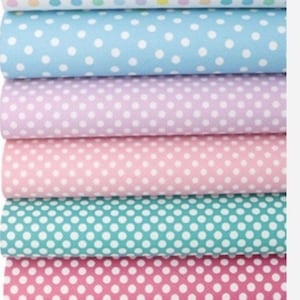 Peut inclure: Une pile de dix feuilles de tissu avec des pois blancs sur des fonds de couleurs différentes. Les couleurs sont jaune, blanc, bleu clair, lavande, rose, turquoise, rose vif, corail et gris.