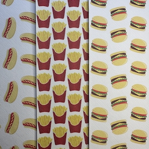 May include: Three fabric panels with repeating patterns of fast food items. One panel features hot dogs with mustard, another shows red cartons of french fries, and the third displays hamburgers with lettuce and tomato.