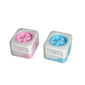 May include: Two small, white, square objects with a fan-like design on top. One has a pink fan and trim, the other has a blue fan and trim. The text "827RPH" is printed on the front of each object.