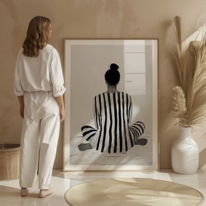 May include: A black and white striped print of a person sitting in a meditative pose. The person is facing away from the viewer and has their hair pulled back in a bun.