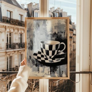 May include: A framed painting of a black and white checkered teacup and saucer on a blue and gray background.