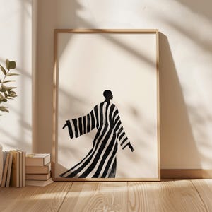 以下が含まれることがあります： 腕を伸ばして歩いている、長いストライプのローブを着た人の白黒のイラスト。イラストは明るい木製のフレームで囲まれています。