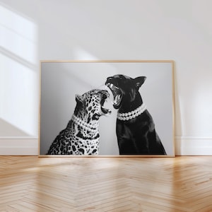 May include: Black and white photograph of a leopard and a black dog wearing pearl necklaces. Both animals are facing each other with their mouths open, as if they are about to fight.