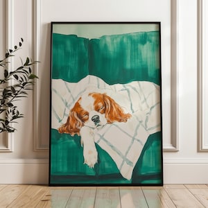 Könnte beinhalten: Ein Aquarellbild eines schlafenden Cavalier King Charles Spaniel auf einem grünen Sofa mit einer weißen Decke. Der Hund ist braun und weiß und hat die Augen geschlossen.