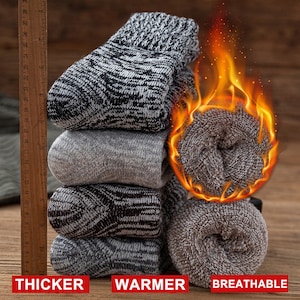 May include: A stack of four pairs of grey and black thermal socks. The socks are thick and warm, and the text "THICKER WARMER BREATHABLE" is printed below the socks.