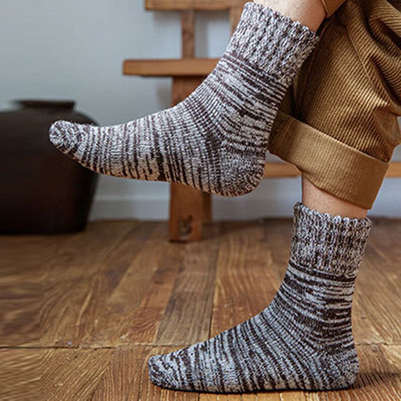May include: A pair of brown and white patterned socks with a ribbed texture. The socks are made of a soft, comfortable material and are ideal for keeping your feet warm in the winter.