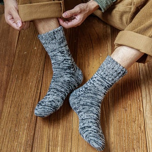 May include: A pair of grey and black patterned socks with a textured knit. The socks are made of a soft, comfortable material and are perfect for keeping your feet warm in the winter.