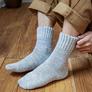 May include: A pair of grey crew socks with a ribbed texture. The socks are made of a soft, comfortable material and are perfect for everyday wear.