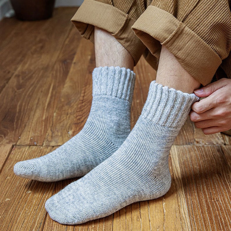 May include: A pair of grey crew socks with a ribbed texture. The socks are made of a soft, comfortable material and are perfect for everyday wear.