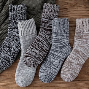 May include: Five pairs of warm, cozy socks in different colors and patterns. The socks are made of a soft, knitted fabric and have a ribbed cuff.