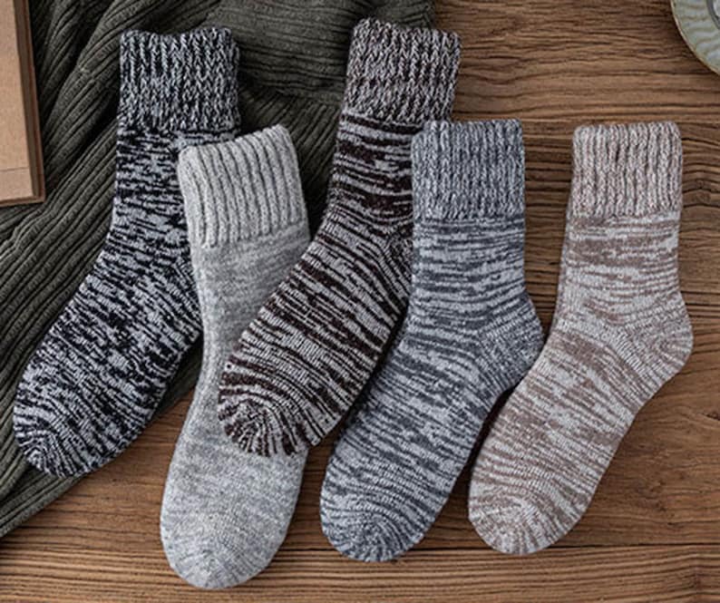 May include: Five pairs of warm, cosy socks in different colours and patterns. The socks are made of a soft, knitted fabric and have a ribbed cuff.