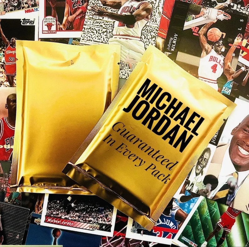 May include: Two gold foil packets with the text "MICHAEL JORDAN Guaranteed In Every Pack" printed on the front. The packets are surrounded by a variety of sports trading cards.