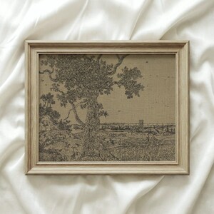 May include: A framed sepia-toned print featuring a detailed pen and ink drawing of a large tree in a landscape. The artwork is set in a light-colored wooden frame, creating a classic aesthetic. The image is on a neutral background.