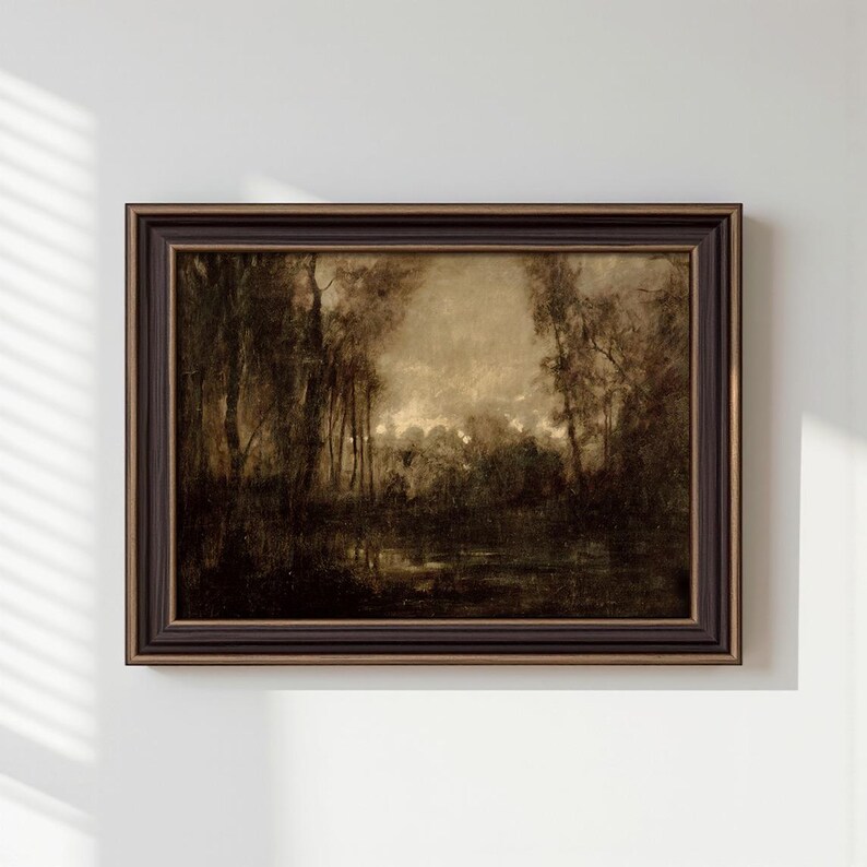 May include: A framed landscape painting in sepia tones depicting a dense forest with tall trees and a dark, reflective body of water in the foreground. The artwork is enclosed in a dark brown, multi-layered wooden frame with subtle gold accents.